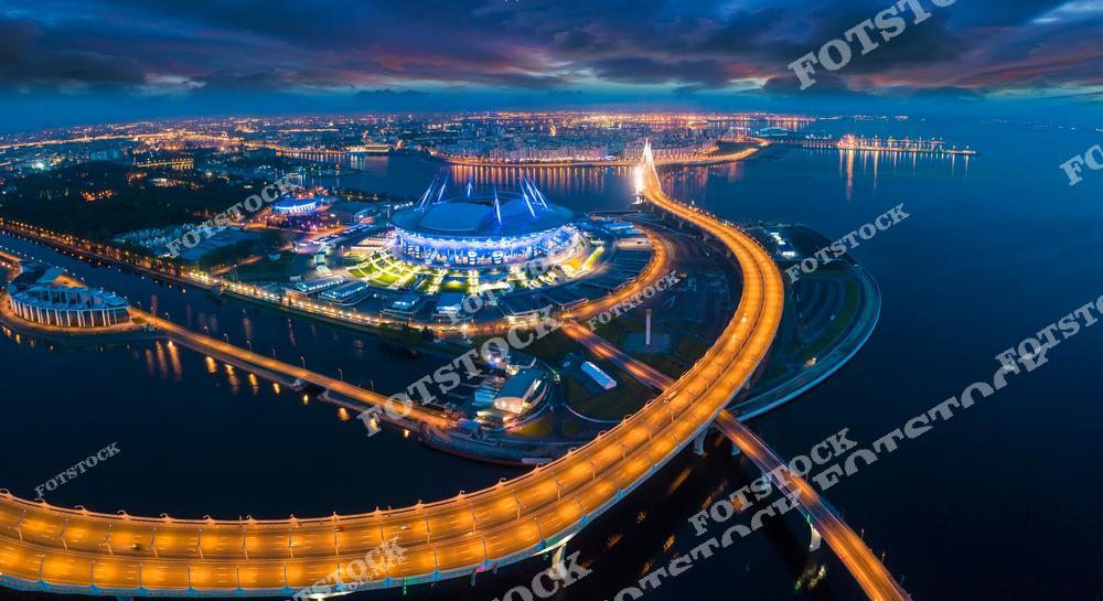 Панорамная фотография Санкт-Петербурга с высоты птичьего полета, на которой запечатлены Крестовский остров, Финский залив, современные улицы города и знаменитый стадион «Газпром Арена». Съемка с дрона позволяет увидеть масштаб городской инфраструктуры, панораму прибрежной зоны и гармоничное сочетание архитектуры и водных пространств. Фотография передает атмосферу современного Петербурга, динамику мегаполиса и красоту северного города у Финского залива. Снимок идеально подходит для туристических публикаций, фотостоков, рекламы, оформления интерьеров и материалов о современных достопримечательностях Санкт-Петербурга.